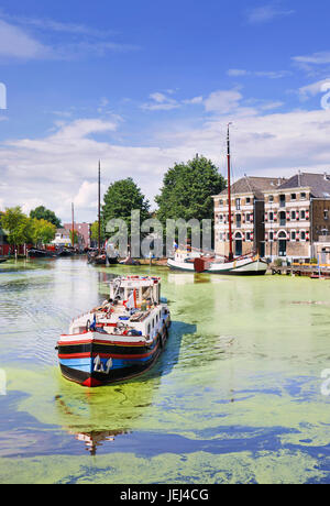 Traditionelles Schiff in einem Kanal mit Grünalgen und einer monumentalen Villa. Stockfoto