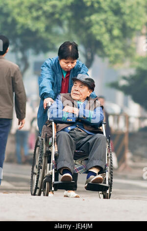 GUANGZHOU – JAN. 8, 2008. Alter Chinese im Rollstuhl. Chinas ältere Bevölkerung (60 oder älter) ist etwa 128 Millionen, einer von zehn Menschen. Stockfoto