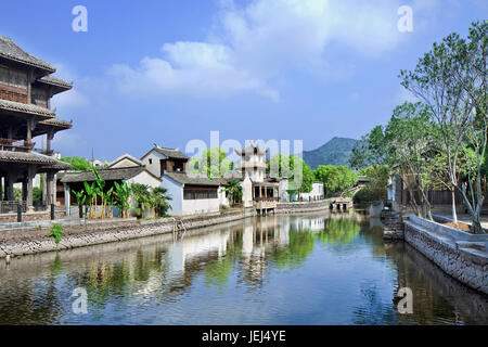 Traditionelle weiße chinesische Häuser spiegeln sich in einem ruhigen Kanal wider, Hengdian World Studios, Hengdian, China Stockfoto