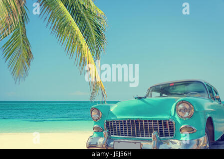 Oldtimer an einem tropischen Strand mit Palme, Vintage Prozess Stockfoto