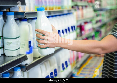 Womans Hand hält Milchflasche Stockfoto