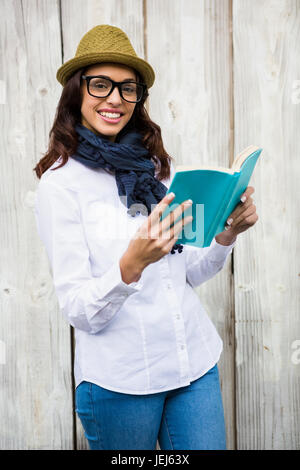 Lächelnde Hipster-Frau, ein Buch zu lesen Stockfoto