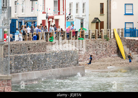 Dorfbewohner, einheimische und Gäste genießen das sommerliche Wetter und einem Drink vor dem Devonport Gasthaus auf der Hafenmauer zu Kingsand, Cornwall Stockfoto