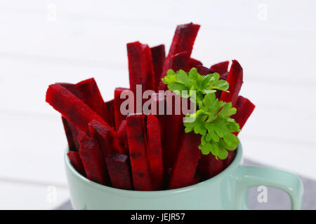 Tasse rote Beete Streifen auf dem grauen Tischset - Nahaufnahme Stockfoto