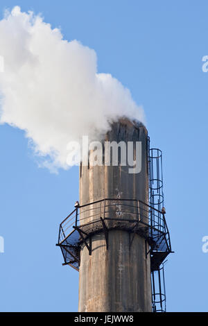 Alten verwitterten Schornstein mit starker Rauchentwicklung Stockfoto