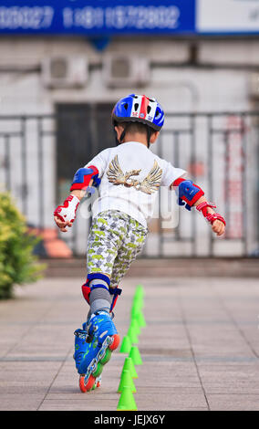 PEKING - 10. JULI 2015. Junge, die Inline-Skating praktizieren. Obwohl Ping-Pong, Basketball, Badminton die besten Sportarten Chinas sind, wurde das Schlittschuhlaufen sehr populär! Stockfoto