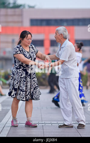 PEKING - 10. JULI 2015. Das kollektive Quadrat-Tanzen ist ein sehr beliebtes Phänomen in China und für viele Menschen eine Art Erholung. Stockfoto