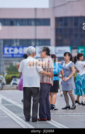 PEKING - 10. JULI 2015. Das kollektive Quadrat-Tanzen ist ein sehr beliebtes Phänomen in China und für viele Menschen eine Art Erholung. Stockfoto