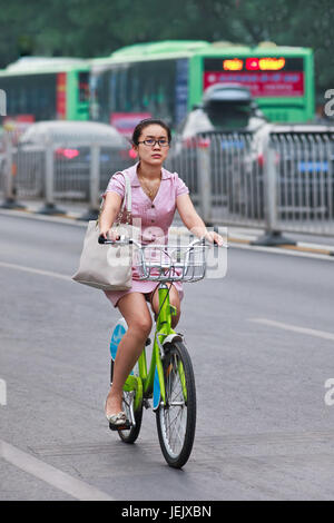 BEIJING-JULI 27, 2015. Elegante Frau fährt Fahrrad öffentliche Freigabe. Fahrrad teilen zu ermöglichen, um auf eine sehr kurzfristig zu mieten, es ist eine sehr beliebte trans Stockfoto