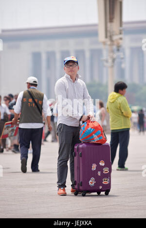 PEKING - 1. JUNI 2015. Tourist mit Koffer auf dem Tiananmen Platz. 2014 erhielt China 3.846 Millionen Touristen. Stockfoto