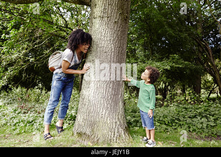 Mutter mit Sohn spielt in der Nähe von Baum Stockfoto