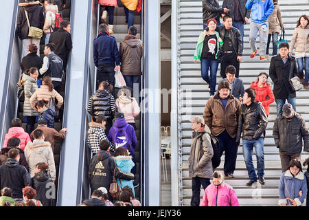 PEKING - 10. MÄRZ 2012. In der Einkaufsgegend Beijing Xidan können Sie sich auf Rolltreppe und Treppe drängen. Stockfoto