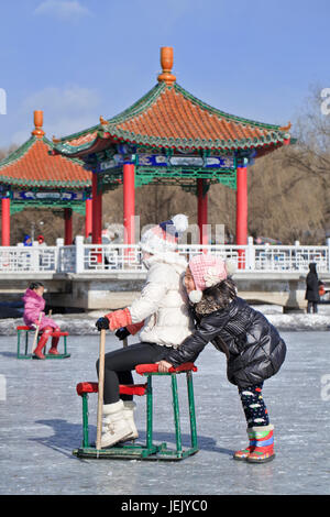 CHANGCHUN - FEB. 4, 2014. Zwei Mädchen haben Spaß auf dem Eis im Nanhu Park Changchun, der Hauptstadt der nordostwärts gelegenen Provinz Jilin. Stockfoto