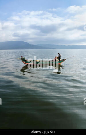 Zwei Personen in einem Fischerboot in den frühen Morgenstunden in Dali, Yunnan Provinz, China Stockfoto