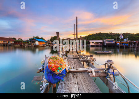 Alte Holzbrücke, die ins Meer mit Sonnenuntergang und lange Belichtung erstreckt. Stockfoto