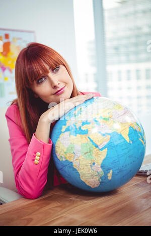 Stütze dich auf einem Globus Hipster Geschäftsfrau Stockfoto