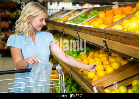 Lächelnde Frau nehmen Orangen Stockfoto