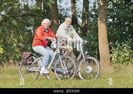 Ältere Paare auf e-bikes. 2014 e-bike Verkäufe mit 16% und die Niederländische erwartet eine Verlangsamung im Jahr 2015 angehoben. Aber in den ersten beiden Quartalen stieg der Umsatz. Stockfoto