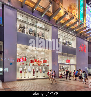 Peking - Juli 6, 2016. H&M outlet Außenansicht bei Nacht. H&M hat seine Marke auf die Herstellung von Faux-Designer-looks zu erschwinglichen Preisen. Stockfoto