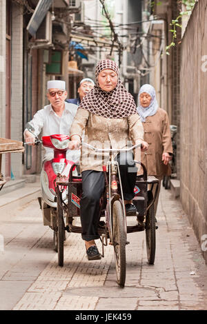 XI'AN, CHINA - 22. MAI 2009. Muslime Zyklen in einer Gasse im muslimischen Viertel Xi'an. Rund 81.500 Menschen gehören zu ethnischen Minderheiten in Xi'an. Stockfoto