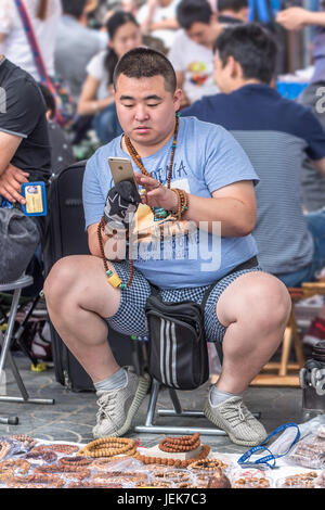 PEKING-29. MAI 2016. Verkäufer auf dem Panjiayuan Markt, ist es der größte Markt, der Antiquitäten, Kunsthandwerk, Sammlerstücke und Dekorationen in China verkauft. Stockfoto