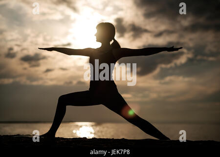 Sportlich fit kaukasischen Frau Asana Virabhadrasana 2 Krieger Pose Haltung in der Natur zu tun. Stockfoto