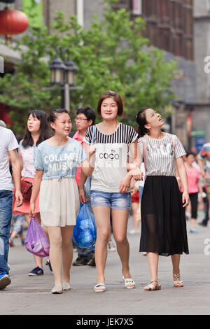 PEKING, 9. JUNI 2015. Junge Mädchen in der Einkaufsstraße. Laut Volkszählung von 2010 ist Chinas unverheiratete Bevölkerung riesig: 249 Millionen 18-und älter. Stockfoto