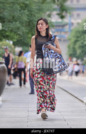 PEKING, 9. JUNI 2015. Attraktive Frau Spaziergänge im Stadtzentrum. Über 27 Jahre und unverheiratete Frauen in China werden als Überbleibsel Frauen gekennzeichnet. Stockfoto