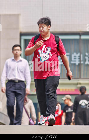 PEKING, 28. APRIL 2016. Übergewichtiger Youngster auf Fußgängerbrücke. Chinas städtische Mittelschicht-Diät hat sich radikal verändert, da es zu einer beginnenden Fettleibigkeit kommt. Stockfoto