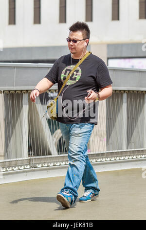 PEKING, 4. MAI 2016. Übergewichtiger Mann auf einer Fußgängerbrücke. Chinas Mittelschicht-Diät hat sich radikal verändert, mit landesweit aufkommenden fettleibig als Ergebnis. Stockfoto
