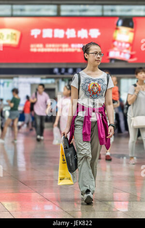 PEKING-21. MAI 2016. Junge Frau am Bahnhof Peking Süd, dem größten Bahnhof der Stadt und einer der größten in Asien. Stockfoto