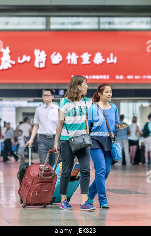 PEKING-21. MAI 2016. Junge Frauen am Bahnhof Peking Süd, dem größten Bahnhof der Stadt und einem der größten in Asien. Stockfoto