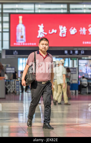 PEKING-21. MAI 2016. Mann mittleren Alters am Bahnhof Peking Süd, dem größten Bahnhof der Stadt und einer der größten in Asien. Stockfoto