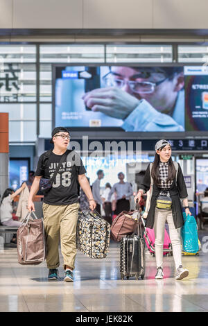 PEKING-21. MAI 2016. Modisches Paar am Bahnhof Peking Süd, der größte Bahnhof der Stadt, Endstation Hochgeschwindigkeitszüge. Stockfoto