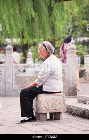 PEKING, 23. AUGUST 2010. Eine alte Dame macht sich in der Nähe des Houhai Sees eine Pause. Chinas ältere Bevölkerung (60 Jahre oder älter) ist derzeit etwa 128 Millionen. Stockfoto