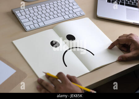 Depressive Gefühle Konzept, Smiley Gesicht Emoticon gedruckt. Stockfoto