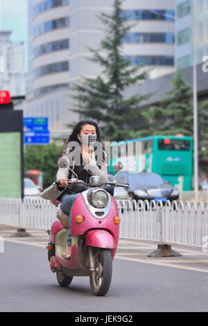 KUNMING - 30. JUNI 2014. Mädchen im Retro-Design E-Bike. Viele Elektrofahrräder in China sind das E-Bike im Roller-Stil, das Pedale haben kann oder nicht. Stockfoto