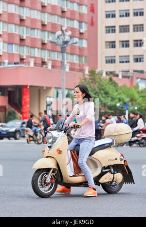 KUNMING - 30. JUNI 2014. Mädchen auf einem E-Bike. Schätzungsweise 200 Millionen Chinesen verwenden jetzt E-Bikes, 1.000-mal mehr als vor 15 Jahren. Stockfoto