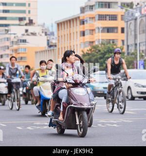 KUNMING - 30. JUNI 2014. Junge Frau auf dem Elektrobike. Viele Elektrofahrräder in China sind das E-Bike im Roller-Stil, das Pedale haben kann oder nicht. Stockfoto