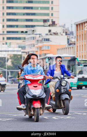 KUNMING - 30. JUNI 2014. Coole Jungs auf E-Bikes. Schätzungsweise 200 Millionen Chinesen verwenden jetzt E-Bikes, 1.000-mal mehr als vor 15 Jahren. Stockfoto