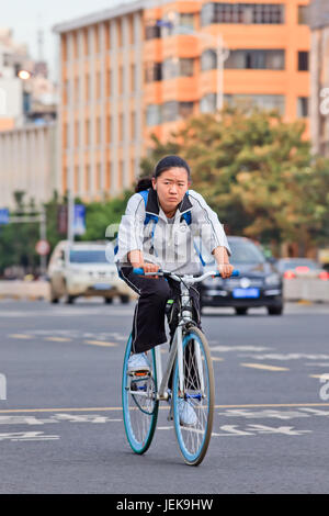 KUNMING - 30. JUNI 2014. Junges Mädchen kehrt nach der Schule zurück nach Hause. Mit 1.342.700.000 Einwohnern verfügt China über 500.000.000 Fahrräder. Stockfoto
