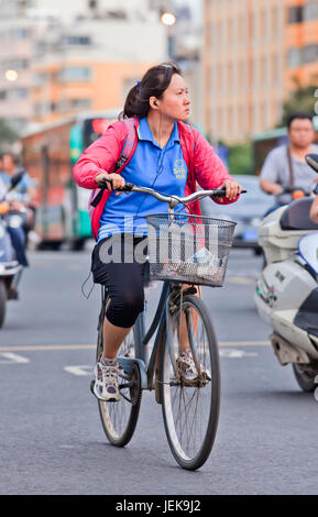 KUNMING - 30. JUNI 2014. Mittelfrau wechselt in der Stadt. China hat 1.342.700.000 und 500.000.000 Fahrräder. Stockfoto