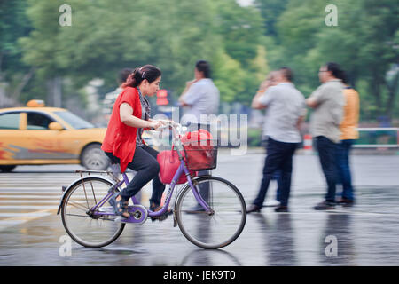 NANJING - 24. MAI 2014. Frau im Regen. Schnee ist in Südchina selten, er fällt nie an der Küste entlang. Stockfoto