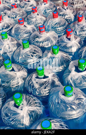 QINGDAO-CHINA - 12. NOVEMBER 2006. Sammlung in blau umhüllten Kunststoffbehältern. Leitungswasser ist in vielen chinesischen Städten nicht für den Verbrauch geeignet. Stockfoto