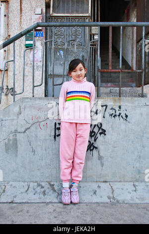 QINGDAO-CHINA-NOV. 12. zwölf Jahre alten Wang Ping vor ihrer Wohnung. Chinas ein-Kind-Politik wurde 1979 eingeführt; schränkt die Paare in städtischen ar Stockfoto