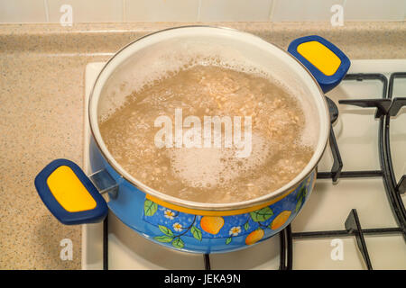 Graupen im Topf auf dem Gasherd Kochen Stockfoto