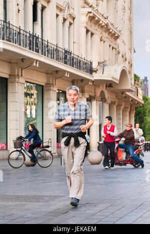 SHANGHAI - 6. MAI 2014. Früher Chinese joggt am frühen Morgen. Es ist überraschend, dass nur wenige Chinesen vor dem Eintritt in den Ruhestand ernsthaft vorgegangen sind. Stockfoto