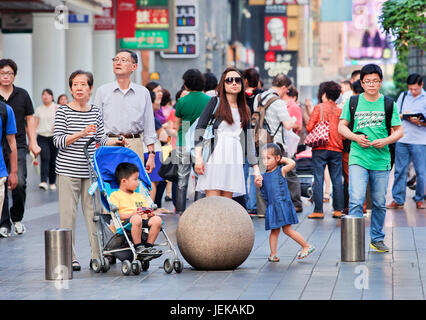 Menschen in Nanjing East Road warten für die Überquerung der Straße. Es ist Shanghais Haupteinkaufsstraße, benannt nach der Stadt Nanjing. Stockfoto