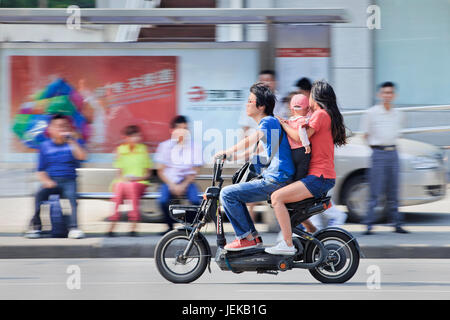 Paar mit Kind auf dem Fahrrad. Chinas Regierung Familienplanung Richtlinie schränkt die offiziell verheiratet, städtischen Paare o nur ein Kind haben. Stockfoto