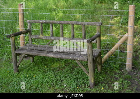Sitzbank aus Holz Holz im Garten Fechten wieder ruhen Ort Garten Retreat Gartenbank Draht einen Platz zum Ausruhen im Sommer Stockfoto